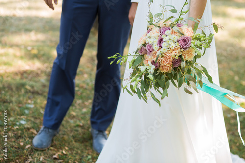 Beautiful Weding bouquet of different flowers in bride hands