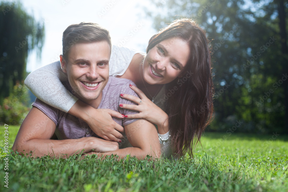 couple lying at grass in park in summer couple lying at grass in park in summer