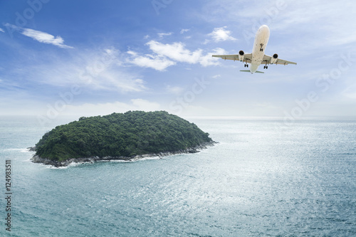  passenger plane flying with beautiful tropical island. photo