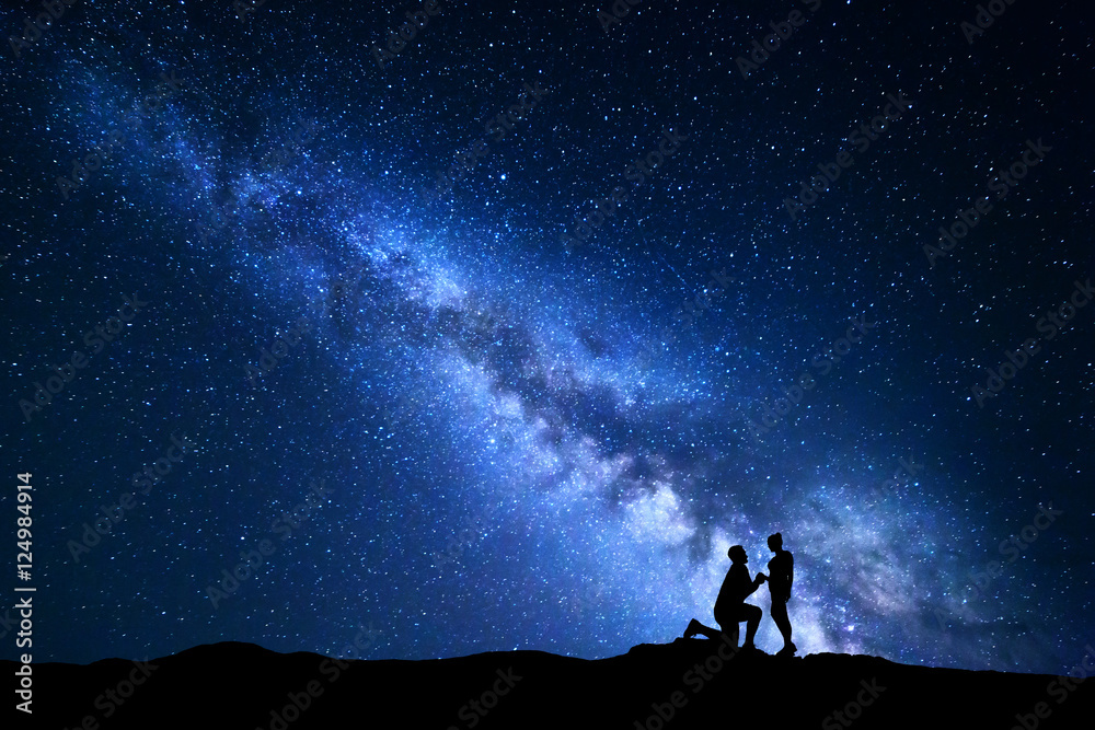 Milky Way. Night landscape with silhouettes of a man making marriage proposal to his girlfriend and starry sky. Silhouette of lovers. Couple, relationship. Blue Milky way with people. Universe - obrazy, fototapety, plakaty 
