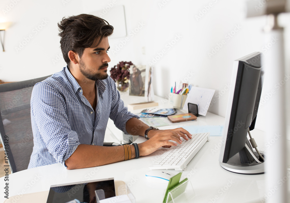 Office worker using computer in his bright office.