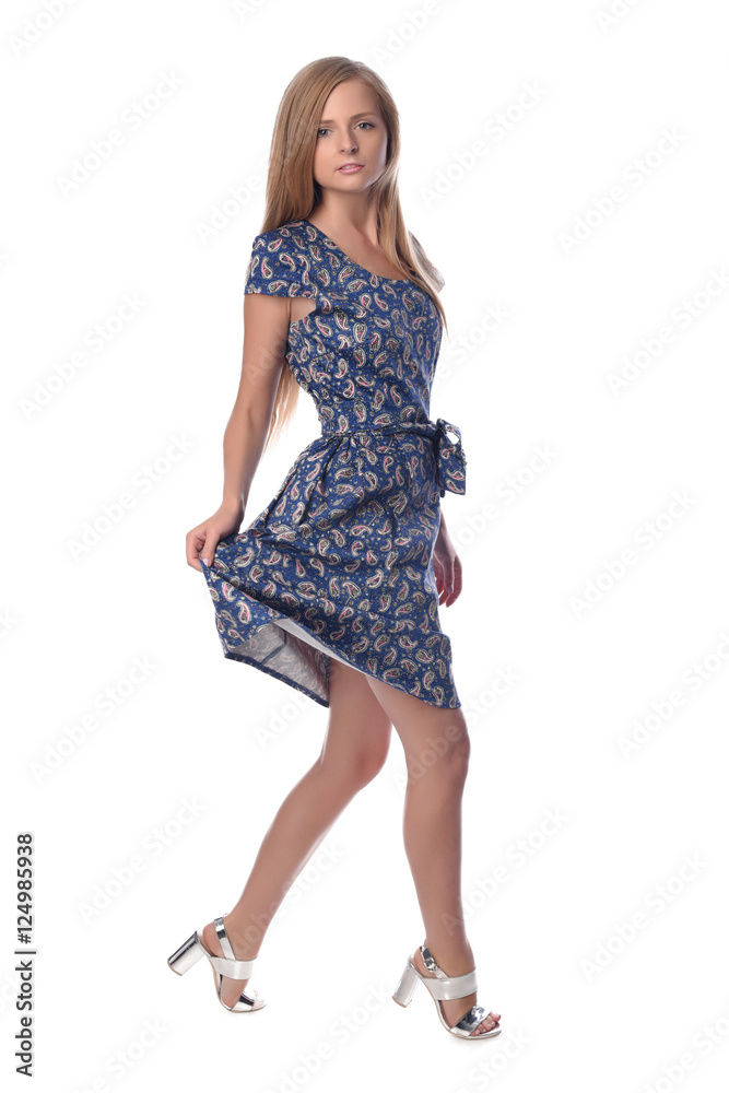 Young pretty long haired blonde woman posing in fashion dress on white background in a studio. Spring summer photo, catalog collection. Young pretty long haired blonde woman posing in fashion dress on white background in a studio. Spring summer photo, catalog collection.