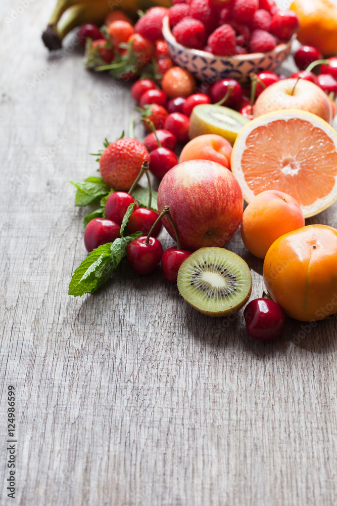 Summer fruits and berries on a dark wooden table, with space for text, selective focus Summer fruits and berries on a dark wooden table, with space for text, selective focus