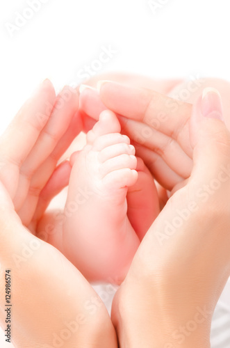 Tiny baby foot in hands of the mother
