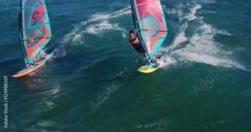 Aerial view of windsurfers gliding across blue ocean, extreme sport