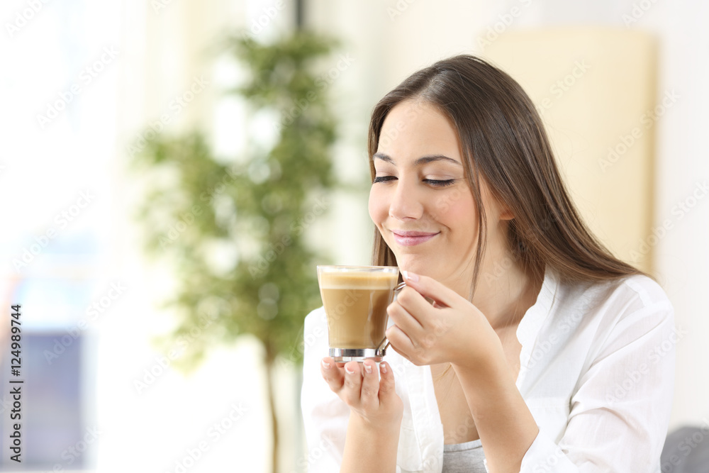 Happy woman enjoying of a cup of coffee with milk Happy woman enjoying of a cup of coffee with milk
