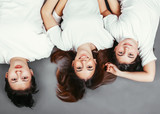 Three sisters lying on the floor upside down