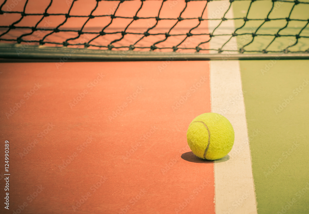 Tennis ball on green tennis court