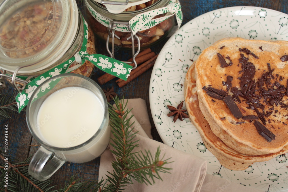 Christmas pancakes from whole wheat flour with chocolate and butter, nuts, muesli, milk. nutritious, healthy, festive Breakfast Christmas pancakes from whole wheat flour with chocolate and butter, nuts, muesli, milk. nutritious, healthy, festive Breakfast