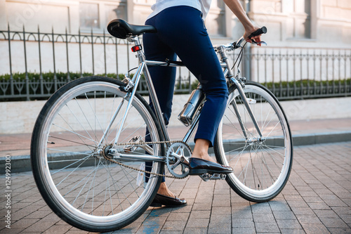 Cropped image of a female biker riding bicycle on street