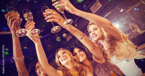 Composite image of pretty girls holding champagne glass