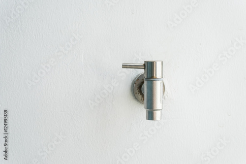 Old rusty silver faucet on white wall with clipping path