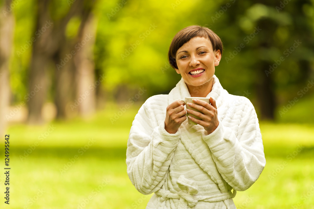 Portrait of beautiful young woman with coffee cup standing in ga Portrait of beautiful young woman with coffee cup standing in ga