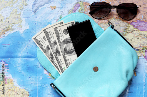 Some staff for travel. Money, glasses, bag, phone, coins are located on the intrenational map. photo