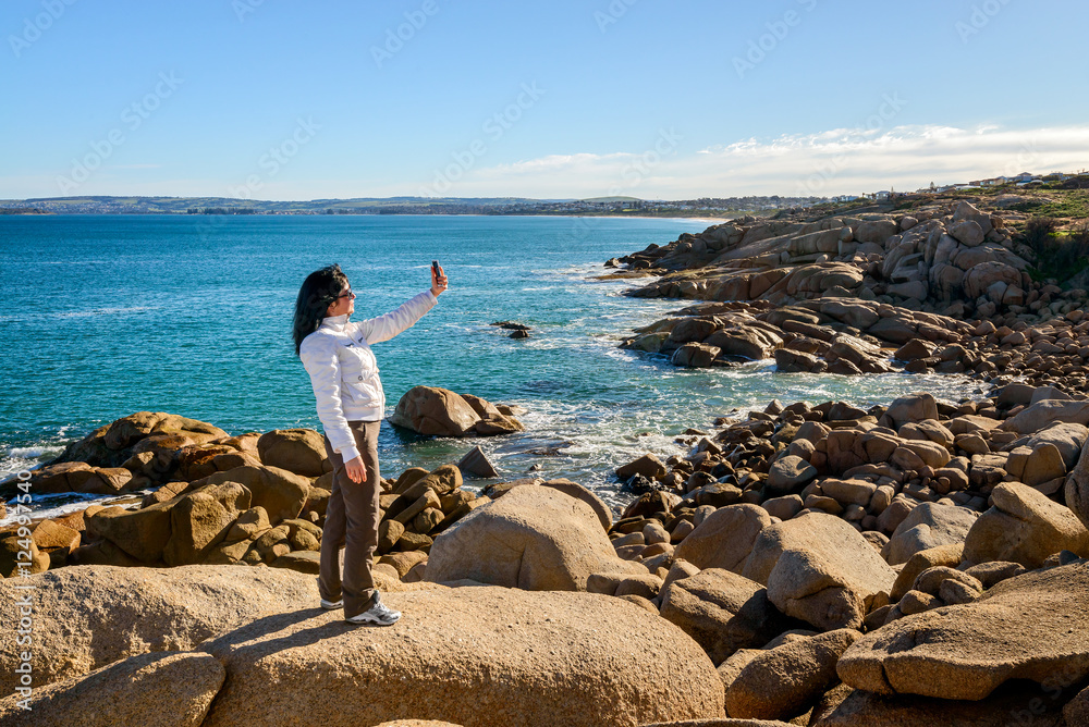 Woman taking selfie with mobile phone on the sea shore Woman taking selfie with mobile phone on the sea shore