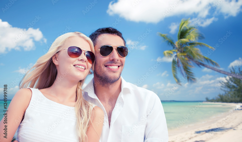 couple in shades over tropical beach background