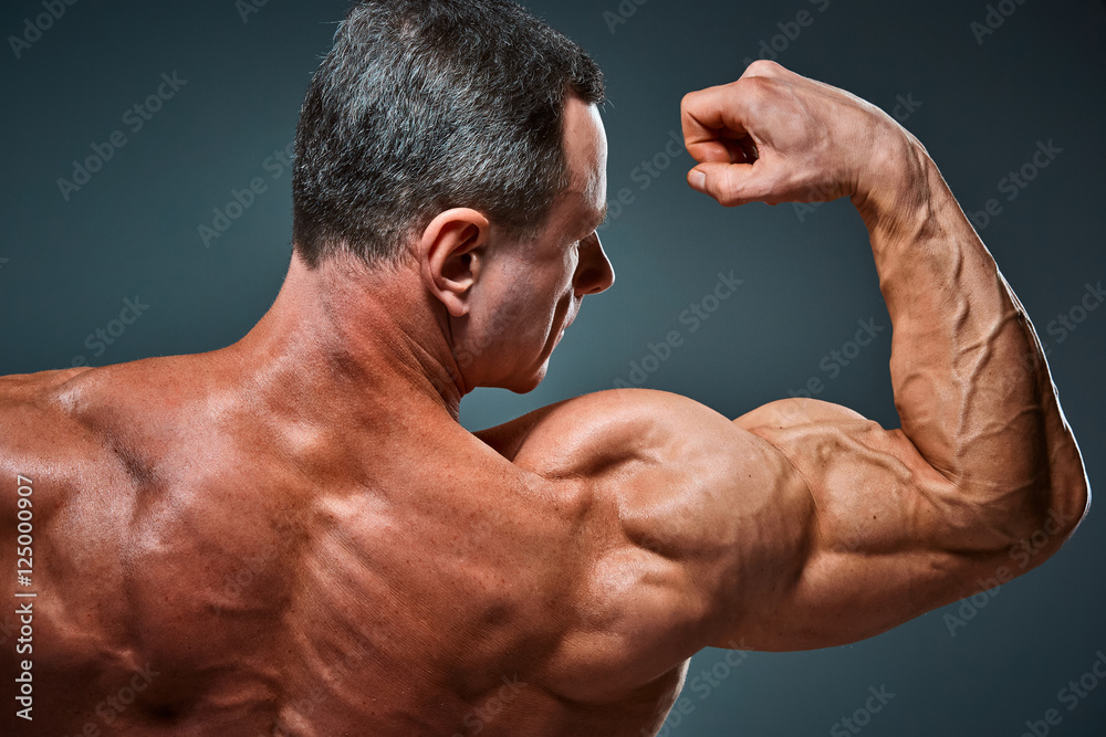 torso of attractive male body builder on gray background. Stock Photo