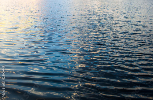 Принти на полотні Water surface with ripples and sunrays reflections