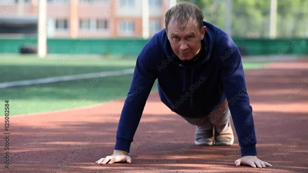 Man doing workout in an outdoor stadium. Morning gymnastics. Man doing workout in an outdoor stadium. Morning gymnastics.