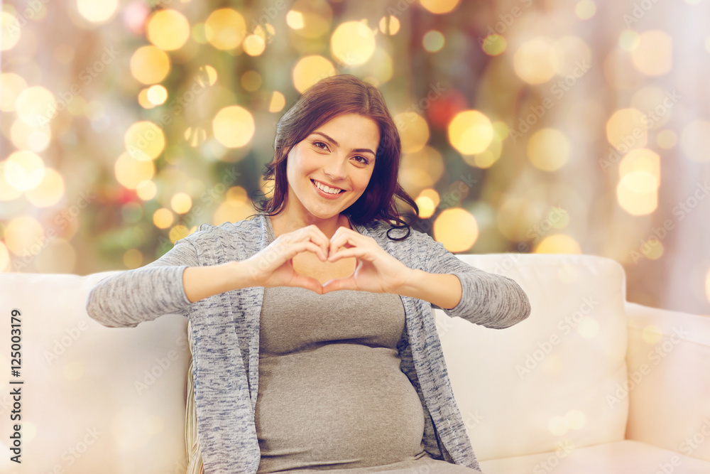 happy pregnant woman making heart gesture at home happy pregnant woman making heart gesture at home