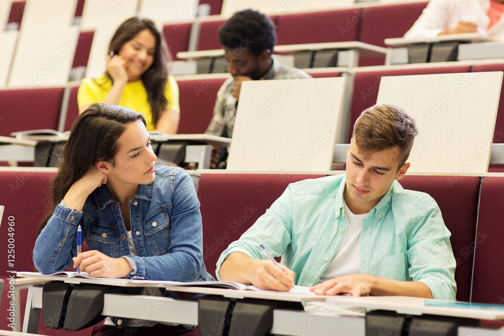 group of students with notebooks in lecture hall group of students with notebooks in lecture hall