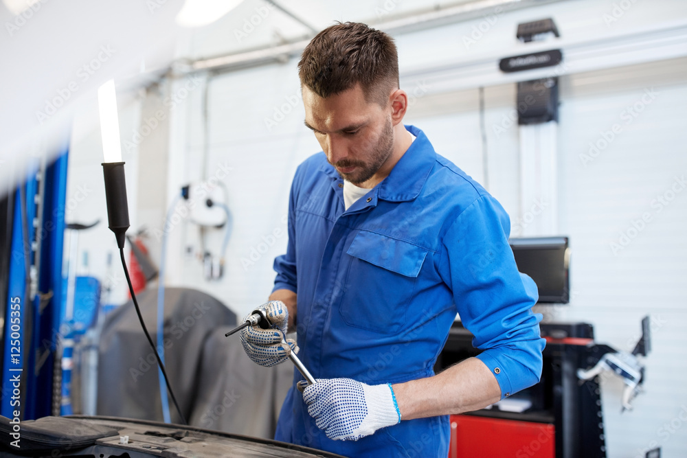 mechanic man with wrench repairing car at workshop mechanic man with wrench repairing car at workshop