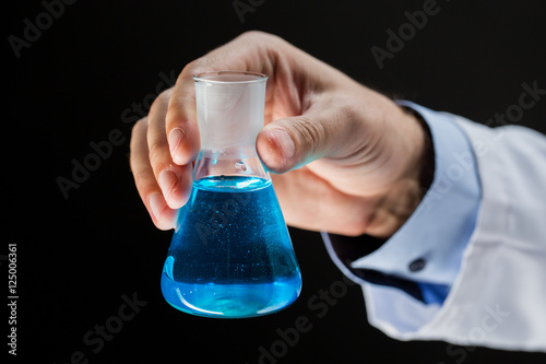 close up of scientist holding flask with chemical