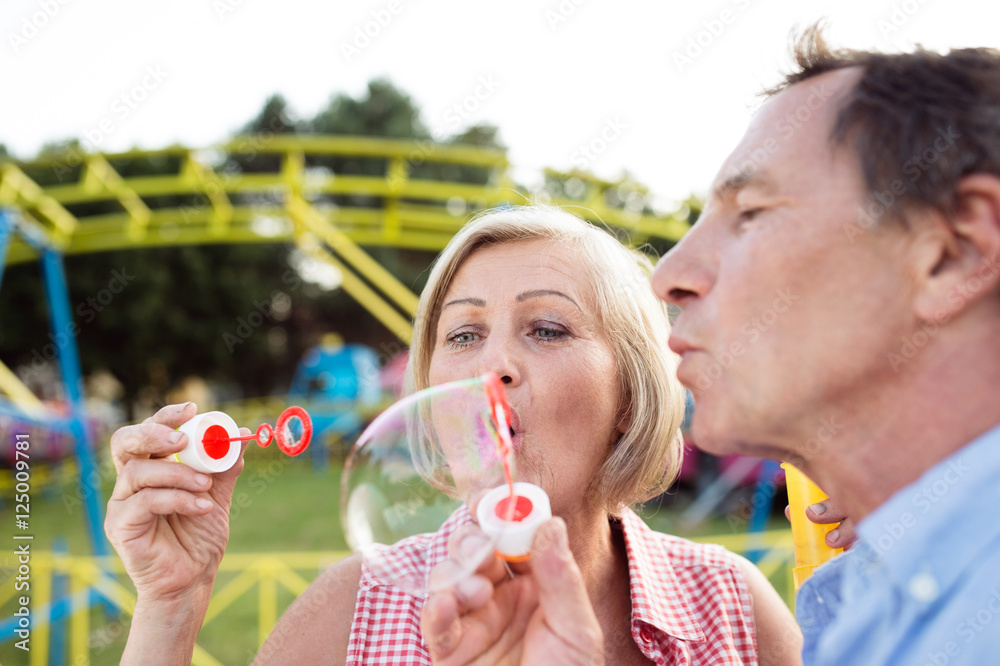 Obraz premium Senior couple having a good time at the fun fair