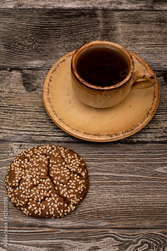 Small cup of coffee, cookies with sesame seeds on wooden background © shmelevevgeniy