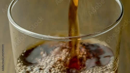 Macro of blackcurrant berry breakfast juice being poured into clear glass drinking cup includes sound, 4K 30p photo