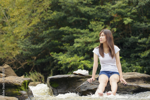 Asian sexy woman sitting on the stone splatter in cascade  Thail