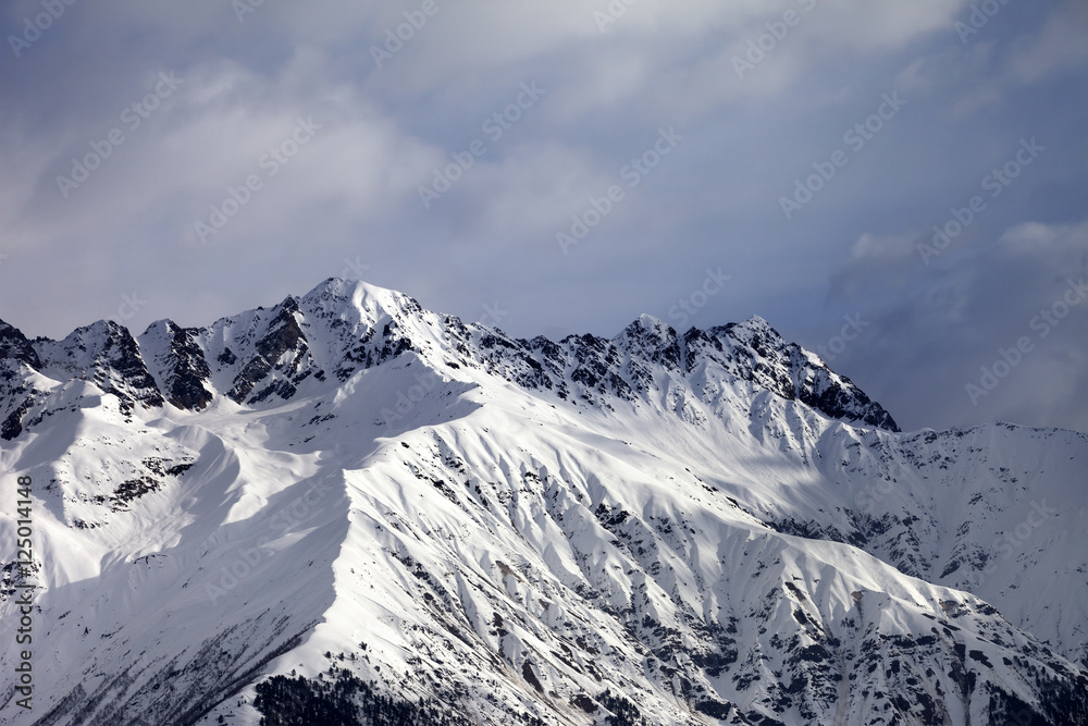 Snow sunlight mountain and cloudy sky at winter evening