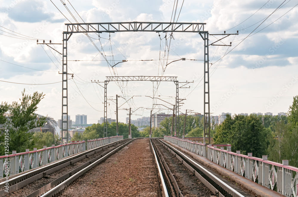 Straight railroad on bridge vanishing in horizon with power line against skyline background. Moscow, Russia.
Straight railroad on bridge vanishing in horizon with power line against skyline background. Moscow, Russia.