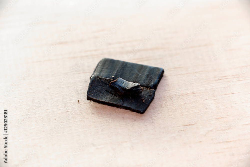 Hashish on Wood. Chunk of hashish, refined cannabis, on wood. Hashish on Wood. Chunk of hashish, refined cannabis, on wood.