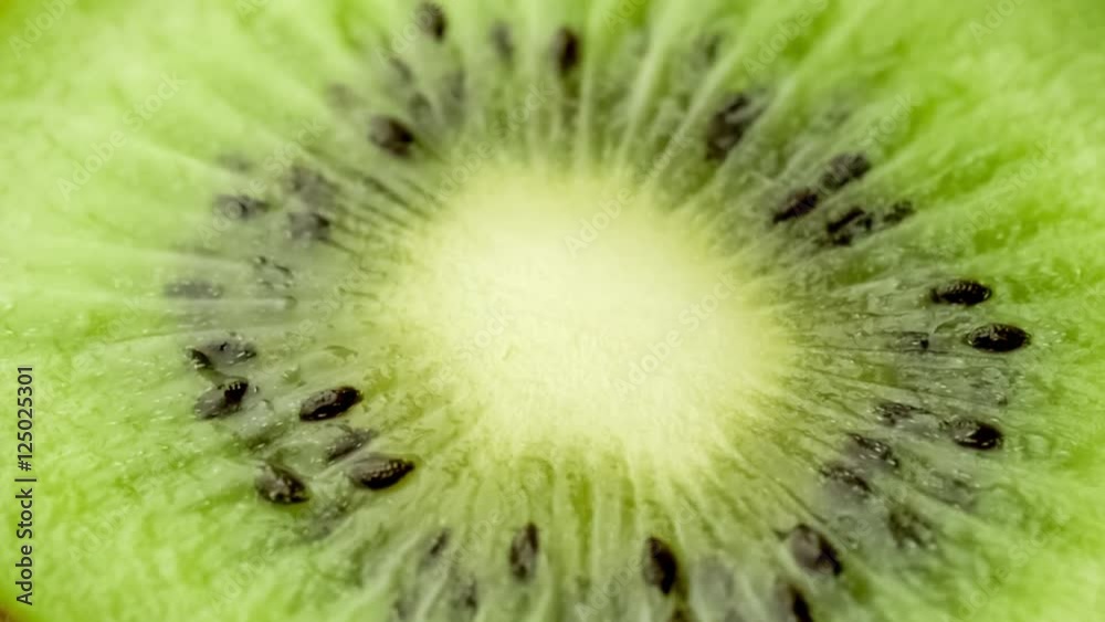 Macro of juicy kiwifruit with seeds as spoon digs in to scoop out green pulpy fruit flesh, slow motion Macro of juicy kiwifruit with seeds as spoon digs in to scoop out green pulpy fruit flesh, slow motion