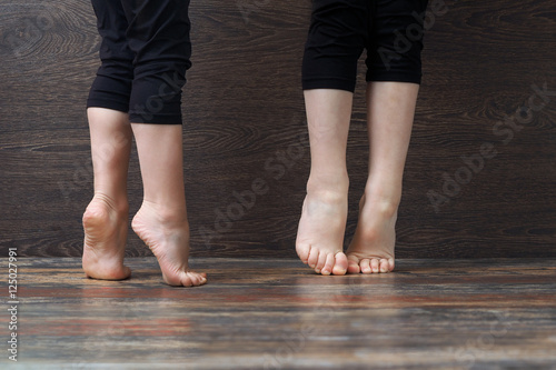 Children's feet on the floor standing on tiptoe