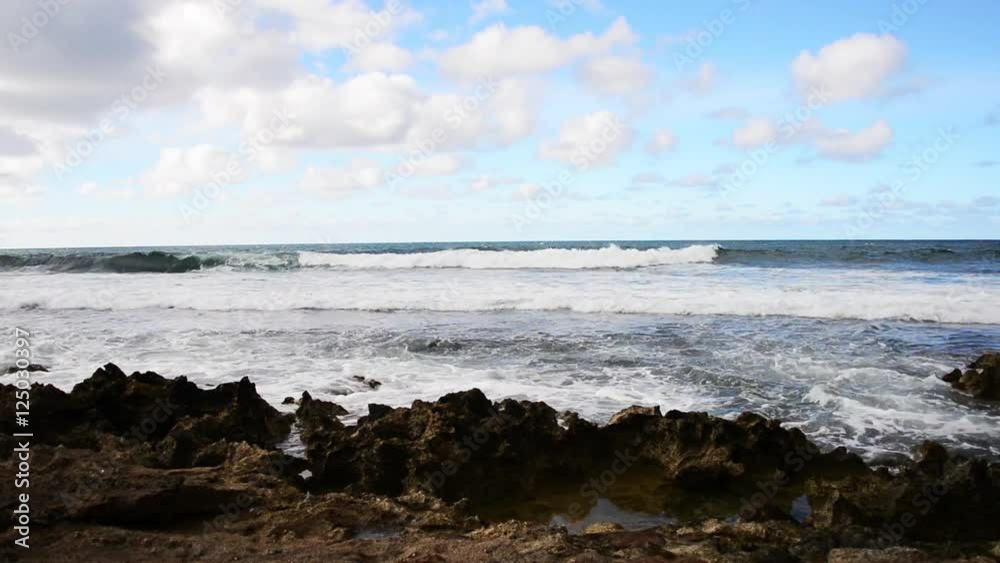 Hawaii seascape, waves crash near rocky shoreline.