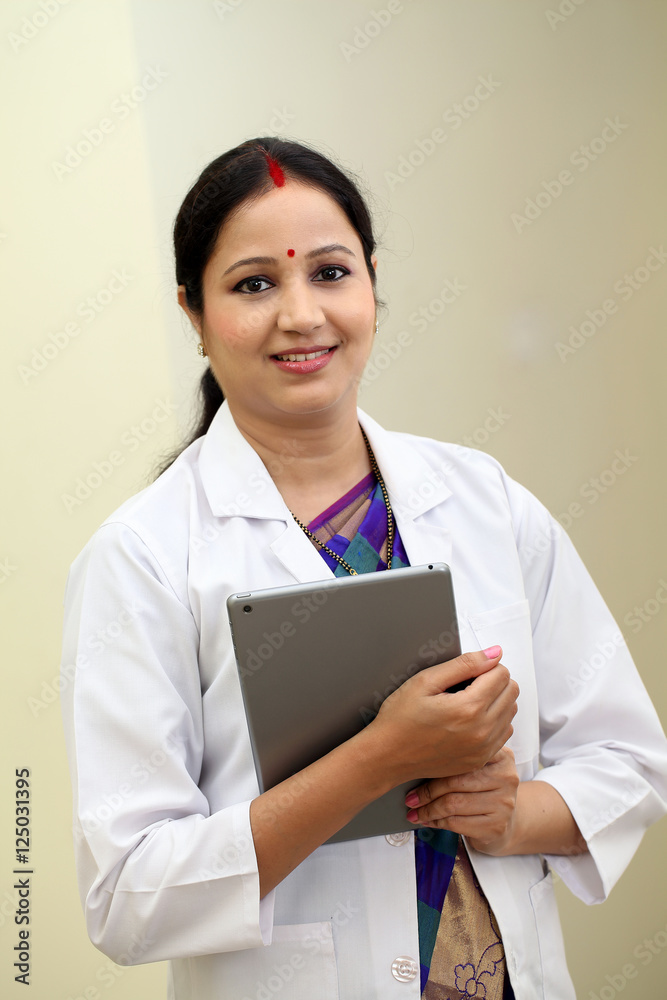 Traditional young female doctor holding tablet computer Traditional young female doctor holding tablet computer