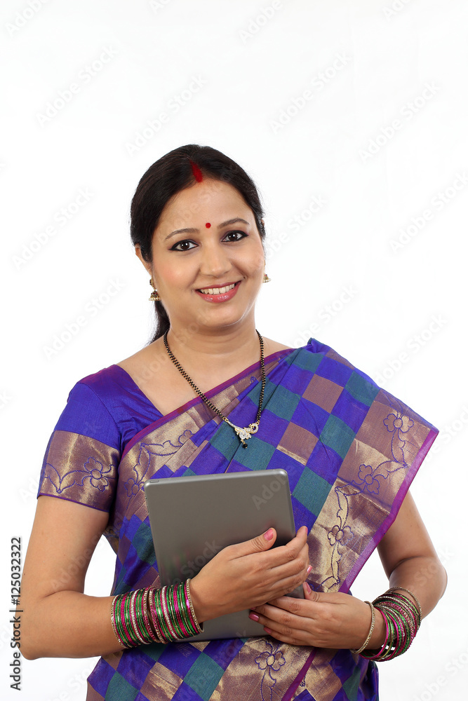 Young traditional woman holding tablet computer against white ba Young traditional woman holding tablet computer against white ba