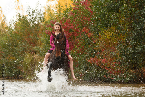 Fototapeta Naklejka Na Ścianę i Meble -  Mädchen mit Pferd im See