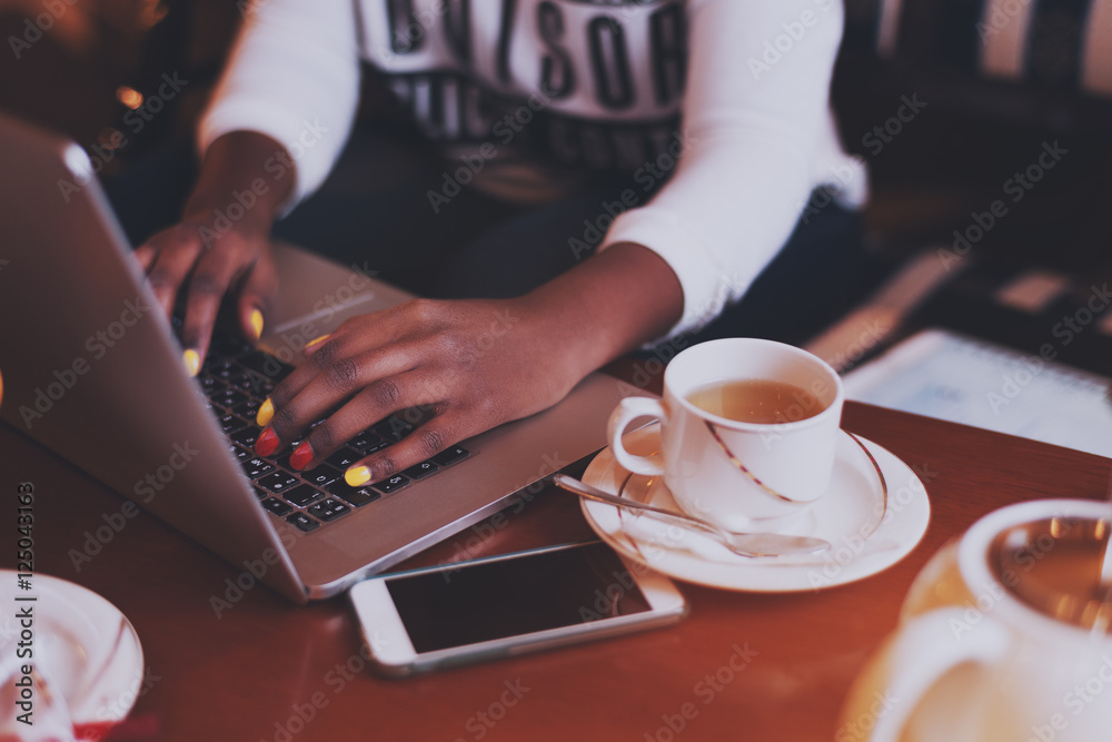 Black hands with .varicoloured nails on laptop keyboard in cafe Black hands with .varicoloured nails on laptop keyboard in cafe