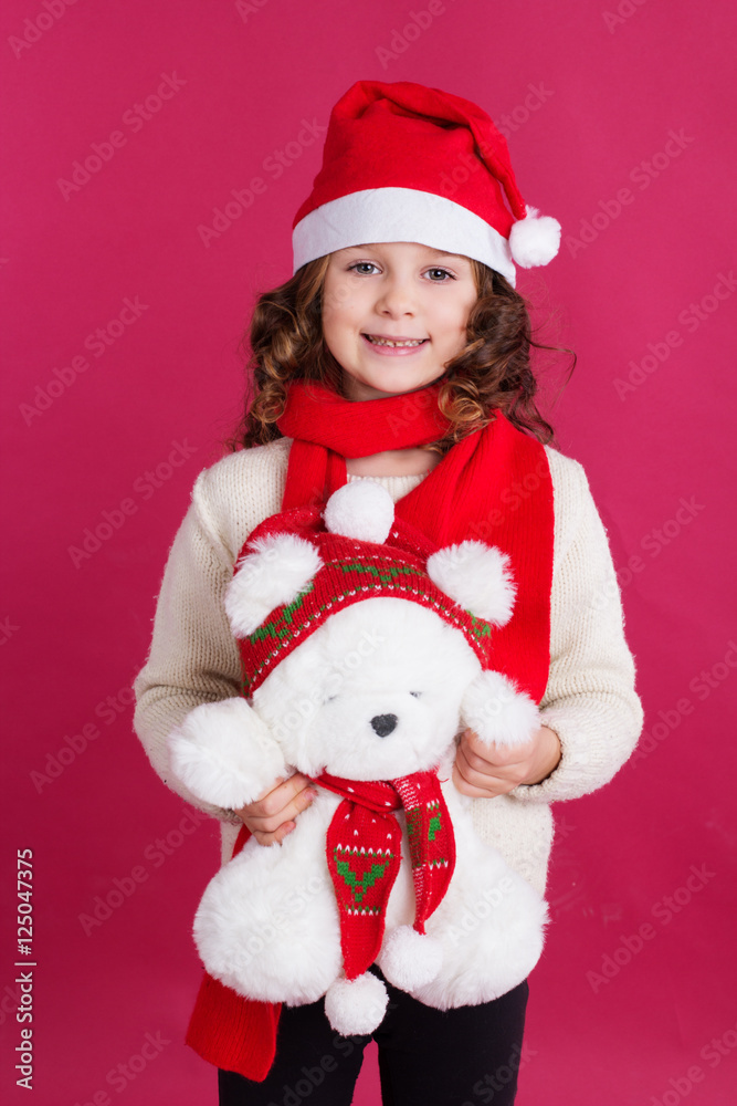 Child girl in santa hat on red background Child girl in santa hat on red background