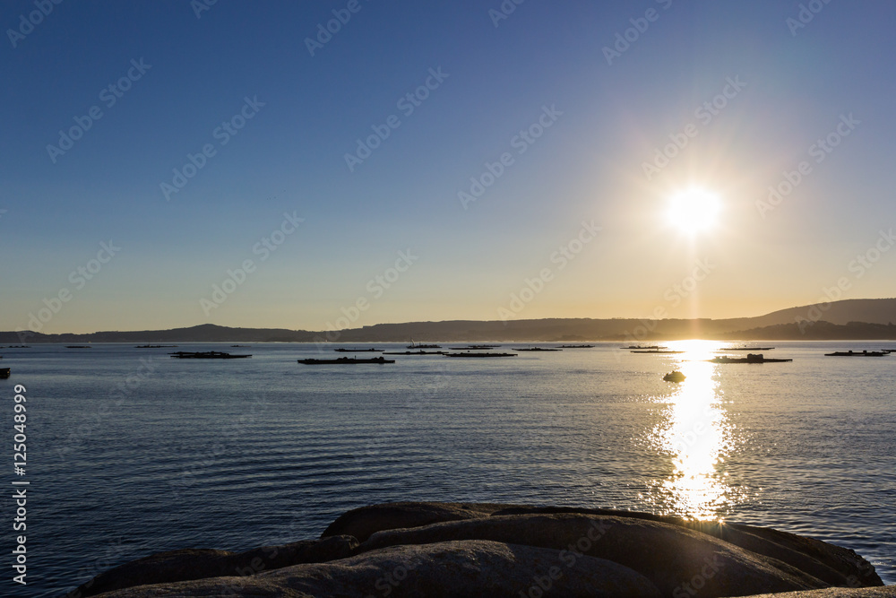 atardecer en la playa con los barcos al fondo