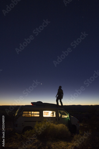 Obraz na plátně Self portrait of the photographer, Woods Wheatcroft, on top of his van at night while camping near the Virgin Mountains of Nevada