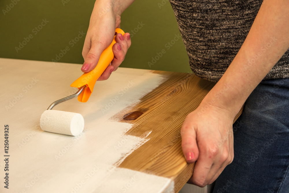 Ein Holztisch wird mit weißer Farbe lackiert Ein Holztisch wird mit weißer Farbe lackiert