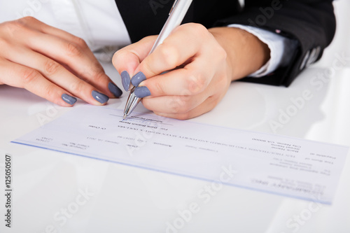 Person's Hand Signing Cheque