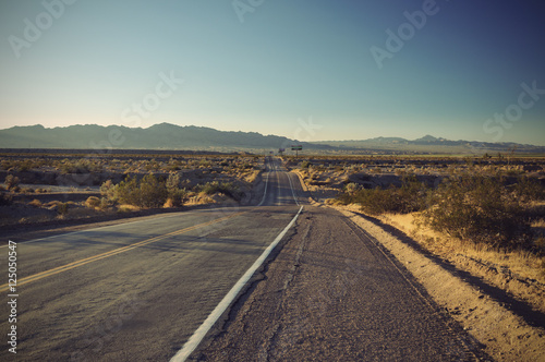 long old asphalt road Route 66 through desert and blue sky