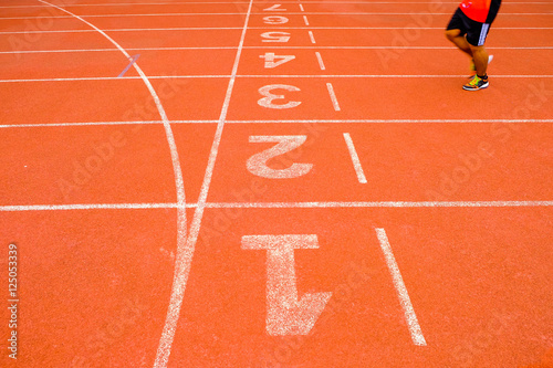 The legs of the men came jogging on a running track to cross the finish line.