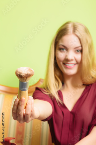 Attractive woman holding powder brush. Make up.