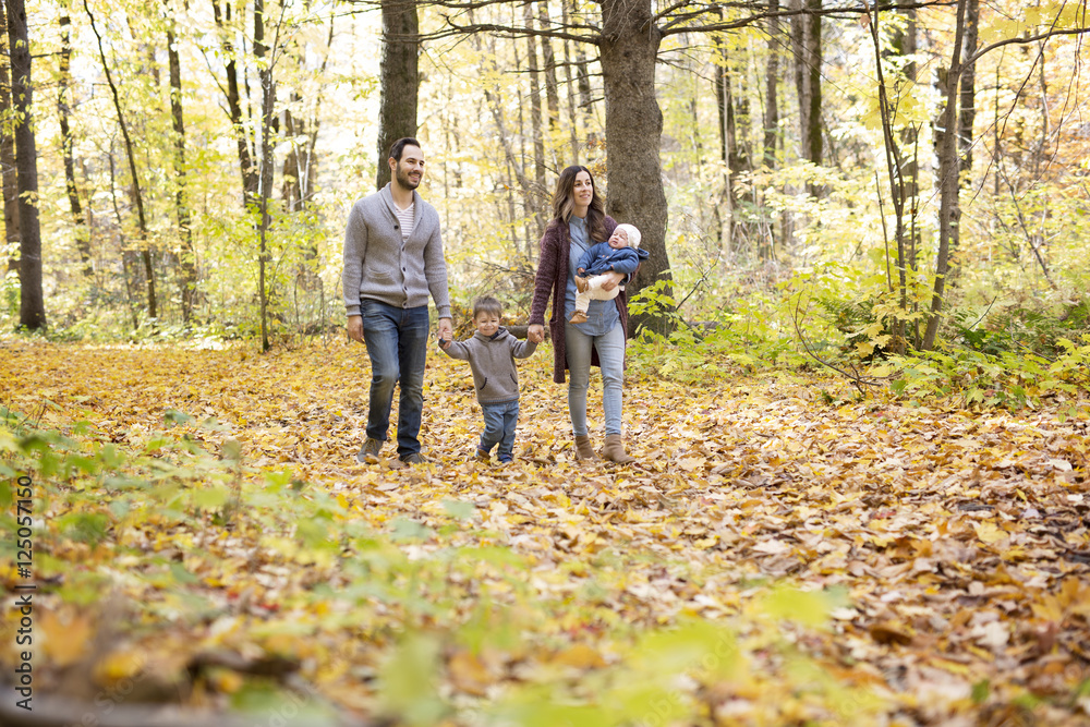 Family of four enjoying golden leaves in autumn park Family of four enjoying golden leaves in autumn park